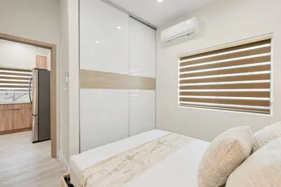 a white bedroom with a bed and a window at Cozy Modern Home w Full Kitchen & Parking