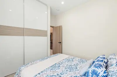 a bedroom with a bed with blue and white sheets at Cozy Modern Home w Full Kitchen & Parking