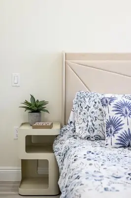 a bedroom with a bed and a nightstand with a plant at Cozy Modern Home w Full Kitchen & Parking