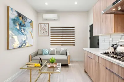 a kitchen and living room with a couch and a table at Cozy Modern Home w Full Kitchen & Parking
