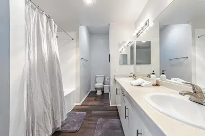 a white bathroom with two sinks and a toilet at 3BR Marina del Rey Condo with Pool, Hot Tub & Parking - 15 Min to LAX in Los Angeles