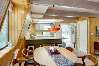 a kitchen and dining room with a table and chairs at Walk to Village Cozy Cabin in Pine Mountain Club! in Pine Mountain Club