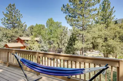 a hammock on the deck of a house at Walk to Village Cozy Cabin in Pine Mountain Club! in Pine Mountain Club