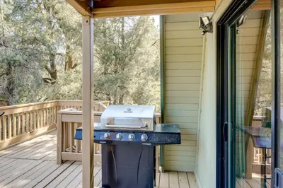 a grill on the porch of a house at Walk to Village Cozy Cabin in Pine Mountain Club! in Pine Mountain Club