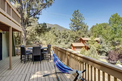 a patio with a table and chairs on a deck at Walk to Village Cozy Cabin in Pine Mountain Club! in Pine Mountain Club