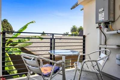 a patio with two chairs and a table on a balcony at Chic 1 Bedroom Loft with Balcony Hollywood Sign View Free Gated Parking Full Kitchen in Los Angeles