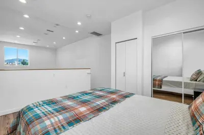 a white bedroom with a bed and a window at Chic 1 Bedroom Loft with Balcony Hollywood Sign View Free Gated Parking Full Kitchen in Los Angeles