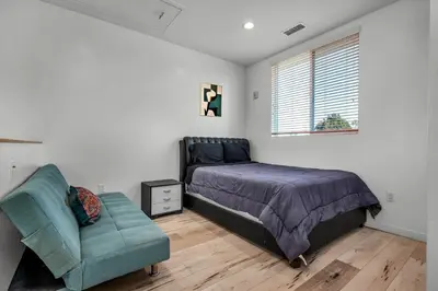a bedroom with a bed and a chair and a window at Koreatown Hollywood Urban Oasis 1 Bedroom Loft with Private Parking and Balcony in Los Angeles