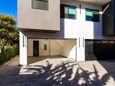 a building with a shadow of a tree on the ground at Modern Luxe Retreat Three-Bedroom #4 in Los Angeles