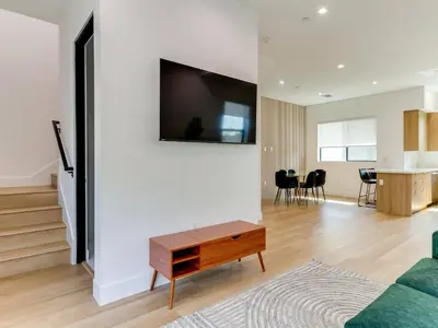a living room with a couch and a tv on a wall at Modern Luxe Retreat Three-Bedroom #4 in Los Angeles