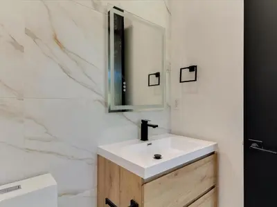 a bathroom with a white sink and a mirror at Modern Luxe Retreat Three-Bedroom #4 in Los Angeles