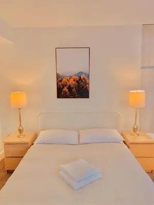 a bedroom with a white bed with two lamps at Western Romaine in Los Angeles