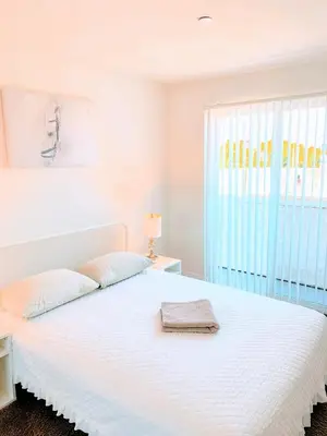 a white bedroom with a white bed with a window at Western Monroe in Los Angeles
