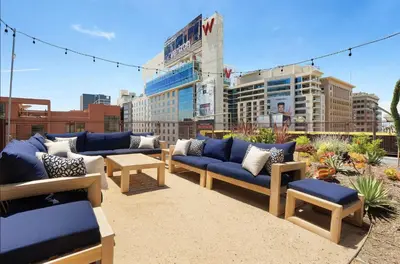 a patio with blue couches and tables and buildings at Loft & Luxe Hollywood with FREE PARKING in Los Angeles