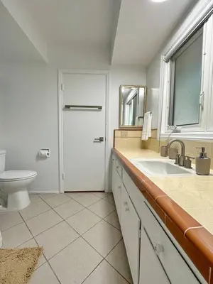 a bathroom with a sink and a toilet and a window at 6BR Pool Escape for Friends and Family - LOU1 - BUR in Burbank