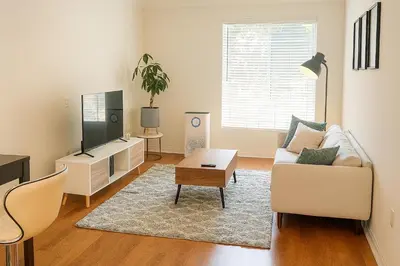a living room with a couch and a tv at LA Koreatown Nest House - Modern, Free Parking, Pool and Sauna, No Cleaning Fee in Los Angeles