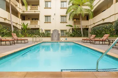 a swimming pool in a hotel with chairs and a building at LA Koreatown Nest House - Modern, Free Parking, Pool and Sauna, No Cleaning Fee in Los Angeles