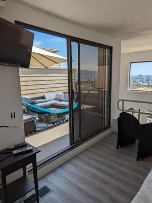 a room with a balcony with a bed and a television at 31 night required rental Waterfront penthouse 180 ocean view in Redondo Beach