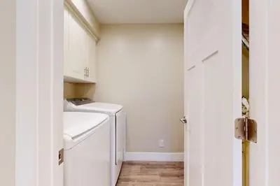 a white laundry room with a washer and dryer at On the Doorstep in Anaheim