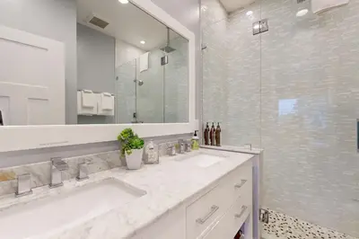 a bathroom with two sinks and a large mirror at On the Doorstep in Anaheim