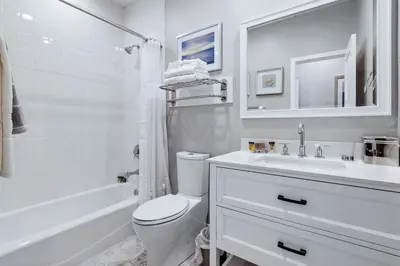 a white bathroom with a toilet and a sink at Mickey's Corner in Anaheim