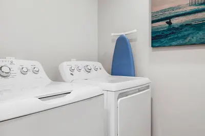 a kitchen with two white appliances and a blue surfboard at Mickey's Corner in Anaheim