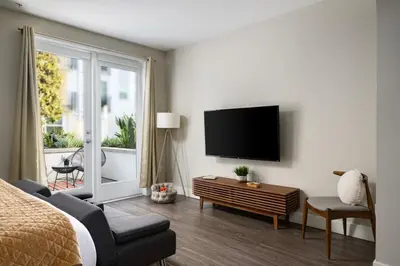 a bedroom with a bed and a tv on a wall at Tangerine Terrace -10 min to Disney&Angel Stadium in Orange