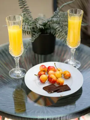 a plate of food on a table with two glasses of orange juice at Tangerine Terrace -10 min to Disney&Angel Stadium in Orange