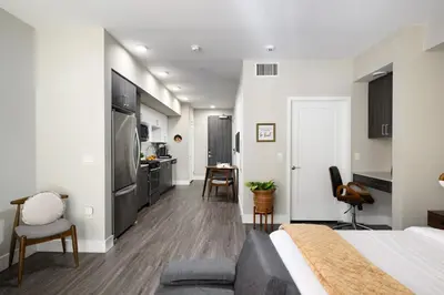 a bedroom with a king sized bed and a kitchen at Tangerine Terrace -10 min to Disney&Angel Stadium in Orange