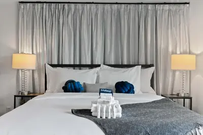 a bedroom with a large white bed with two blue back packs at New Listing Burbank Bungalow by Colby&Conrad in Los Angeles