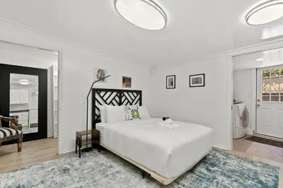 a white bedroom with a large bed and a bathroom at New Listing Burbank Bungalow by Colby&Conrad in Los Angeles