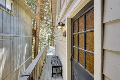 a door to a house with a bench on a porch at 2 Mi to Lake Arrowhead Pet-Friendly Cabin in Lake Arrowhead