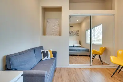 a living room with a blue couch and a bedroom at 4 Mi to Beverly Hills Quiet LA Gem with Shared Yard in Los Angeles
