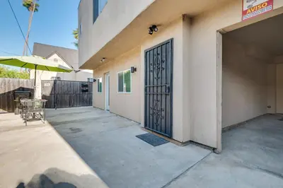 a door to a building with a patio and an umbrella at 4 Mi to Beverly Hills Quiet LA Gem with Shared Yard in Los Angeles