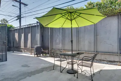 a table with two chairs and a yellow umbrella at 4 Mi to Hollywood Mid-Wilshire Couples Retreat in Los Angeles