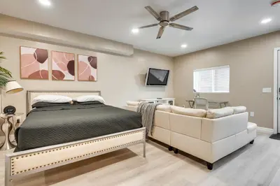 a bedroom with a bed and a couch and a ceiling fan at 4 Mi to Hollywood Mid-Wilshire Couples Retreat in Los Angeles