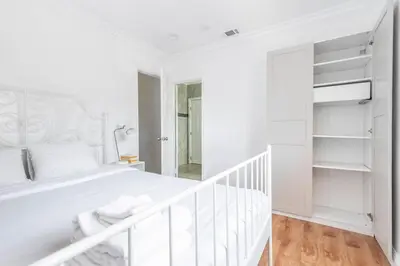 a white bedroom with a white bed and a staircase at Ideal 4BR2BA Home for Family Vacations in Alhambra