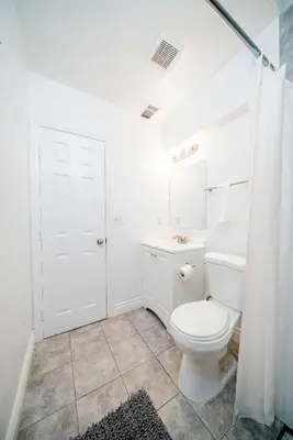 a white bathroom with a toilet and a shower at Cozy 2BR2BA Guest House in Alhambra in Alhambra