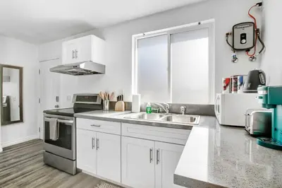 a white kitchen with a sink and a stove at Cozy Guesthouse near Downtown Alhambra in Alhambra