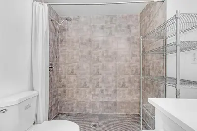 a bathroom with a shower and a toilet and a sink at Cozy Guesthouse near Downtown Alhambra in Alhambra