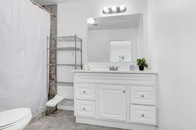 a white bathroom with a sink and a toilet at Cozy Guesthouse near Downtown Alhambra in Alhambra