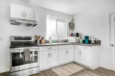 a kitchen with white cabinets and a stove top oven at Cozy Guesthouse near Downtown Alhambra in Alhambra