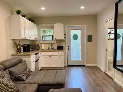 a living room with a couch and a kitchen at Guest suite near La Cienega Park Beverly Hills next to LACMA La Brea Tar Pits Peterson Museum and Academy Awards Museum in Los Angeles
