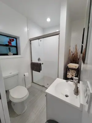 a white bathroom with a toilet and a sink at Guest suite near La Cienega Park Beverly Hills next to LACMA La Brea Tar Pits Peterson Museum and Academy Awards Museum in Los Angeles