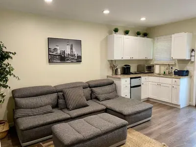 a living room with a couch and a kitchen at Guest suite near La Cienega Park Beverly Hills next to LACMA La Brea Tar Pits Peterson Museum and Academy Awards Museum in Los Angeles