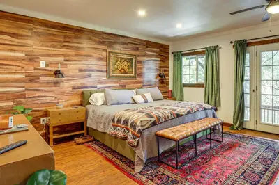 a bedroom with a bed and a wooden wall at 3 Mi to Lake Arrowhead Village Dog-Friendly Cabin in Lake Arrowhead