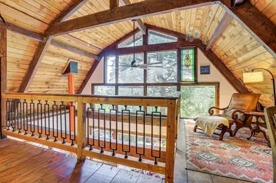 a living room with a large window in a cabin at 3 Mi to Lake Arrowhead Village Dog-Friendly Cabin in Lake Arrowhead