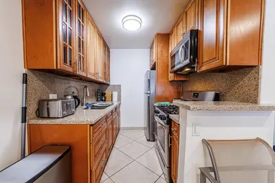 a small kitchen with wooden cabinets and appliances at Amazing Berryman 1bd#8 in Los Angeles