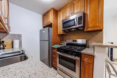 a kitchen with stainless steel appliances and wooden cabinets at Amazing Berryman 1bd#8 in Los Angeles