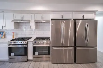 a kitchen with stainless steel appliances and white cabinets at Stylish Private Ensuite Room near USC in Los Angeles
